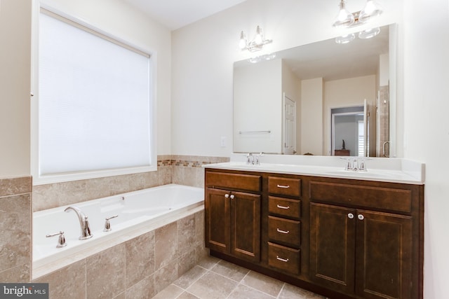 bathroom with tile patterned flooring, vanity, and tiled tub