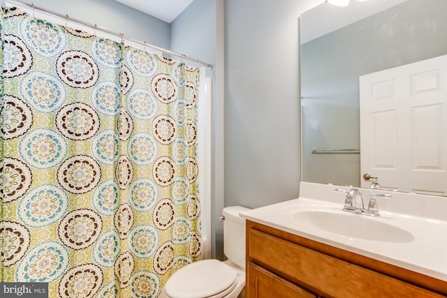 bathroom with vanity, curtained shower, and toilet