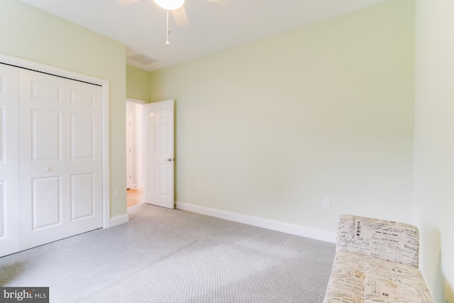 unfurnished bedroom with ceiling fan, light colored carpet, and a closet