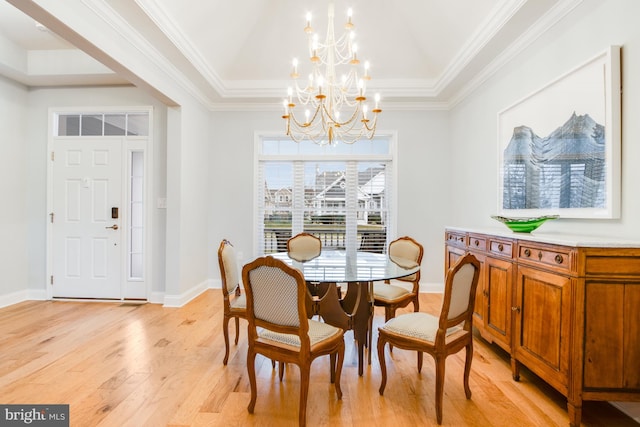 dining space featuring a chandelier, light wood-type flooring, and crown molding