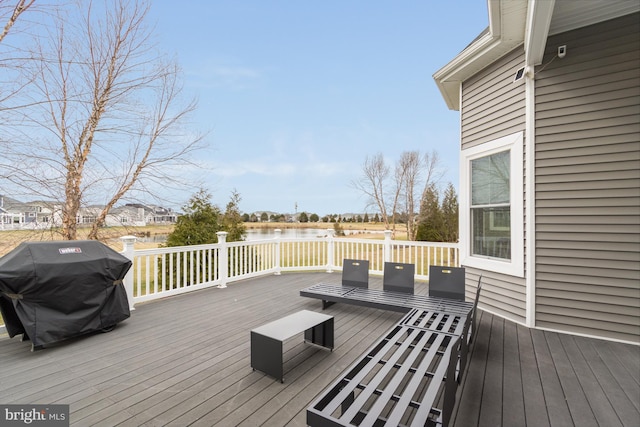 wooden terrace featuring a grill and a water view