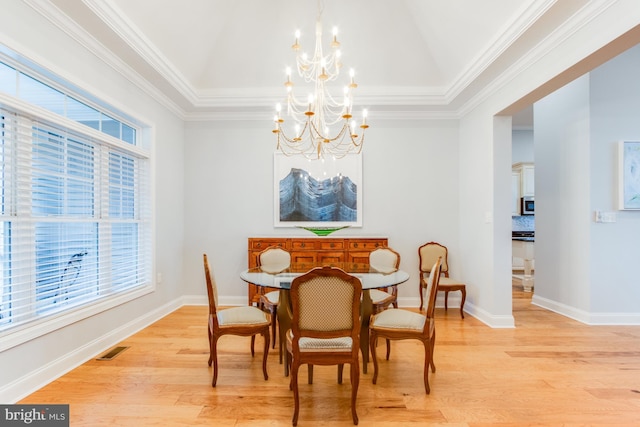 dining room with a notable chandelier, light wood-type flooring, and ornamental molding