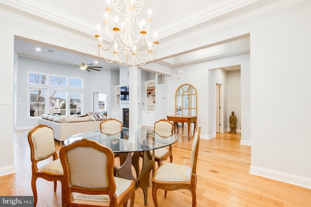 dining room featuring ceiling fan with notable chandelier, light wood-type flooring, and ornamental molding