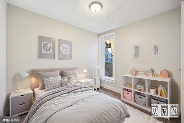 bedroom featuring radiator heating unit, carpet, and a textured ceiling