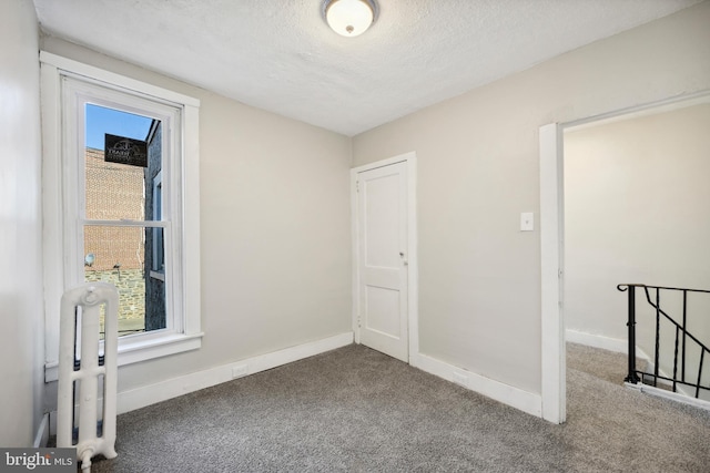 carpeted spare room with a textured ceiling