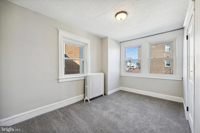 carpeted spare room featuring radiator