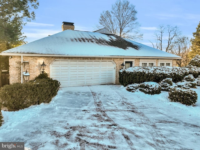 view of snowy exterior featuring a garage