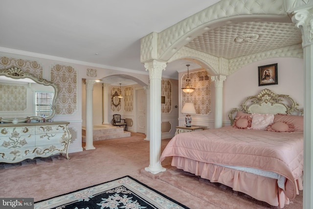 bedroom featuring decorative columns, crown molding, and carpet