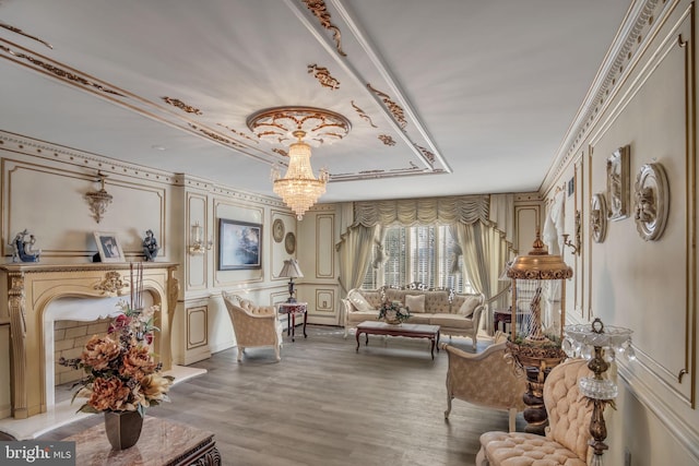 sitting room featuring wood-type flooring, an inviting chandelier, and crown molding