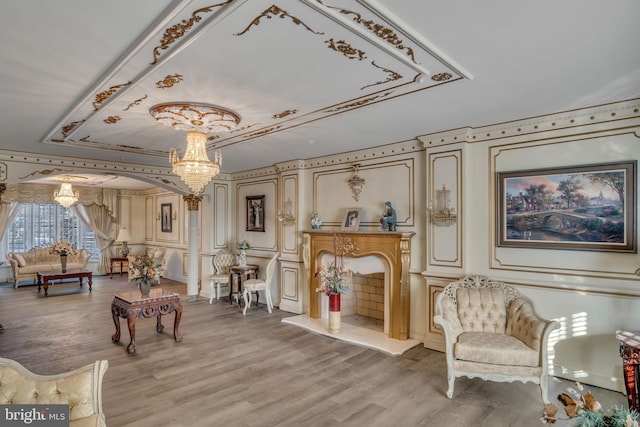 sitting room with a chandelier, hardwood / wood-style floors, and ornamental molding