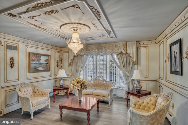 living area with hardwood / wood-style floors, a baseboard radiator, and a notable chandelier