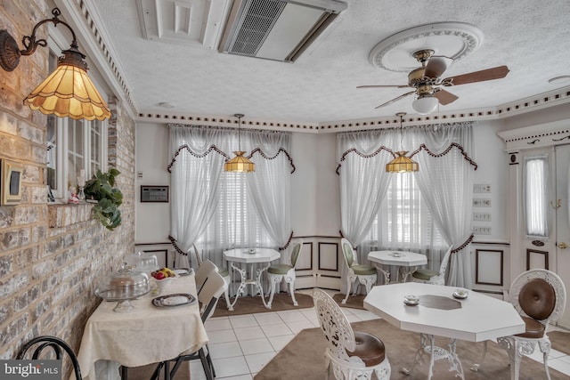 dining space featuring ceiling fan, light tile patterned floors, and a textured ceiling