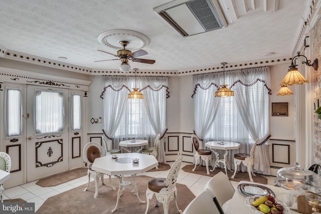 sitting room with ceiling fan, light tile patterned flooring, and a textured ceiling