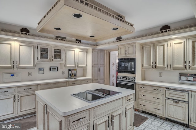 kitchen with cream cabinets, a kitchen island, and black appliances