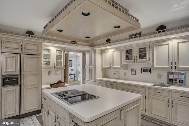 kitchen with a center island, black electric cooktop, sink, and cream cabinets