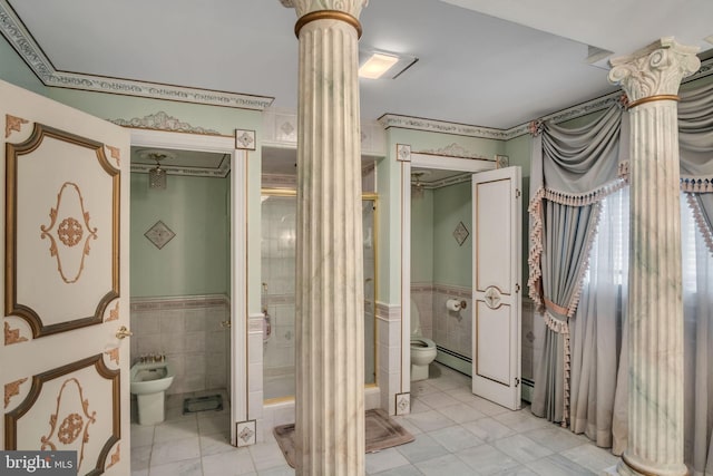 bathroom with a bidet, a baseboard heating unit, toilet, tile walls, and decorative columns