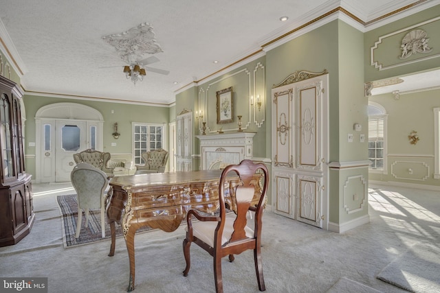 carpeted dining space featuring a textured ceiling, ceiling fan, and ornamental molding