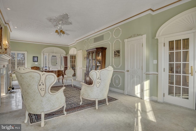 carpeted living room featuring a textured ceiling, ceiling fan, and crown molding