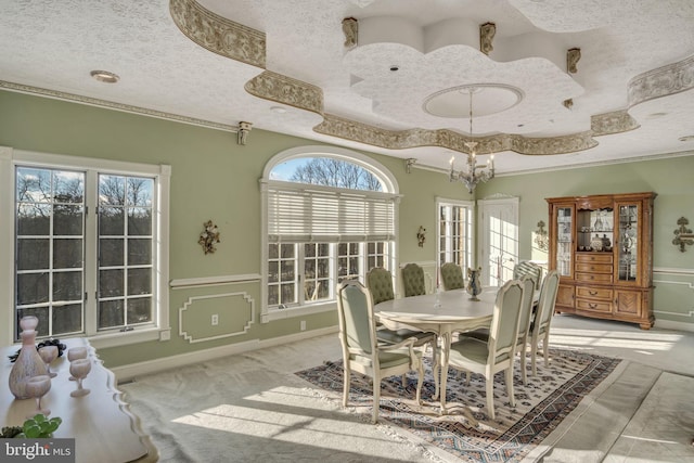 carpeted dining room with a chandelier, a textured ceiling, and a tray ceiling