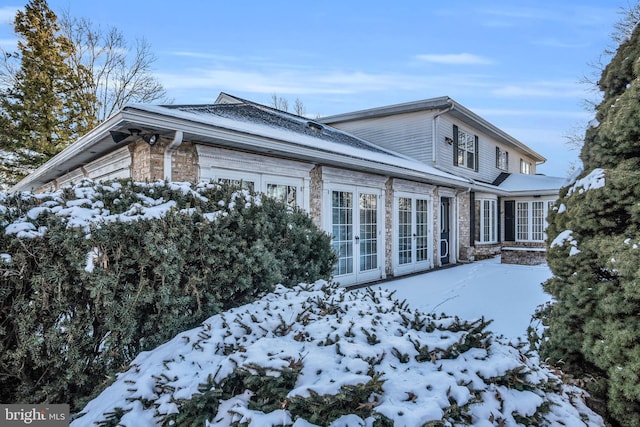 view of snowy exterior featuring french doors