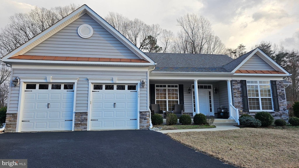 view of front of property featuring covered porch and a garage