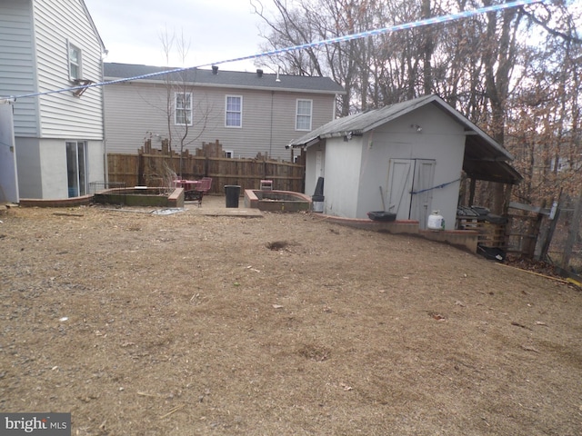 rear view of house featuring a storage shed