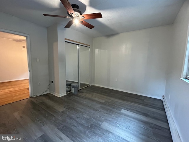 unfurnished bedroom with ceiling fan, a closet, dark hardwood / wood-style floors, and a baseboard heating unit