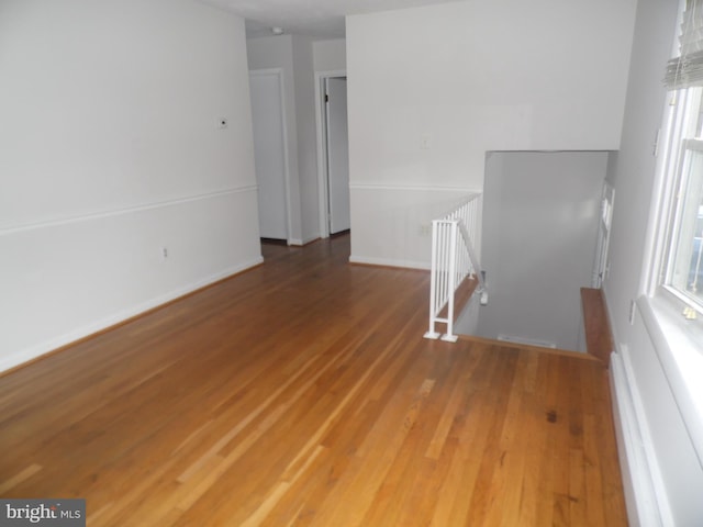 empty room with hardwood / wood-style flooring and baseboard heating