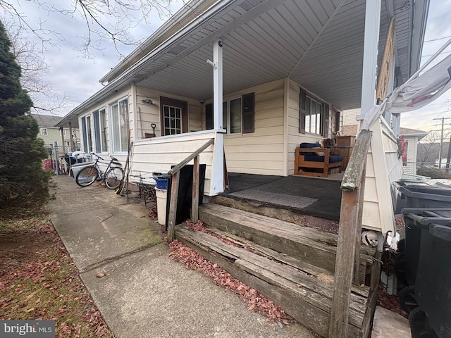 view of exterior entry featuring covered porch