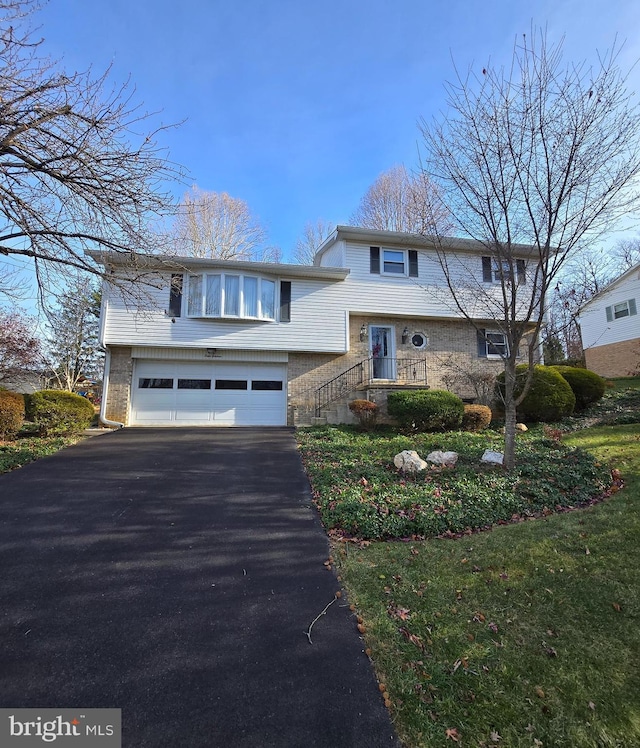 view of front of property featuring a front yard and a garage