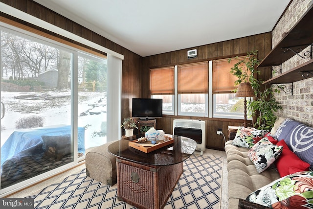 living room featuring light colored carpet, heating unit, and wooden walls