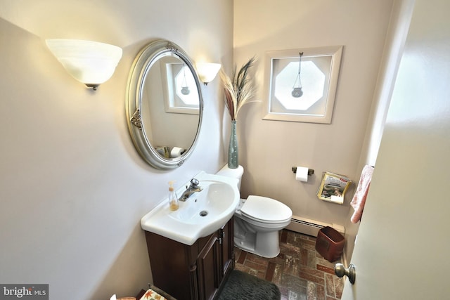 bathroom with a baseboard heating unit, toilet, and vanity