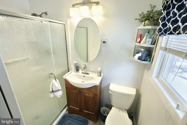 bathroom featuring toilet, an enclosed shower, and vanity