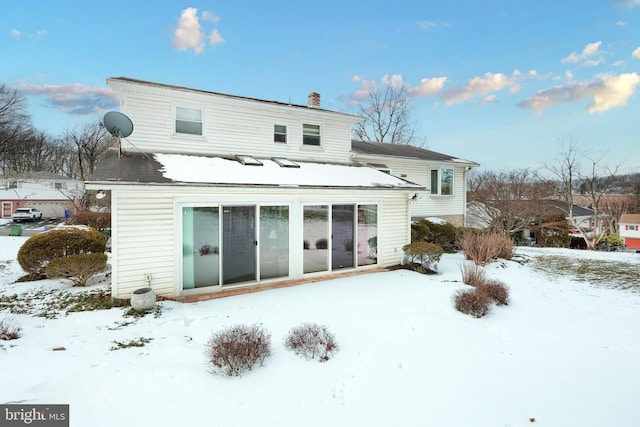 view of snow covered rear of property