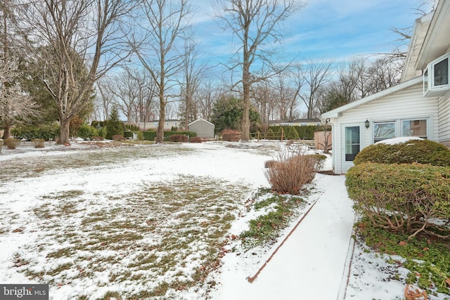 yard covered in snow featuring a storage unit