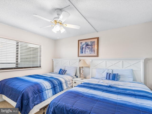 bedroom featuring carpet, ceiling fan, and a textured ceiling