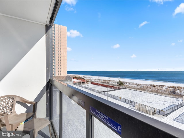 balcony featuring a water view and a beach view