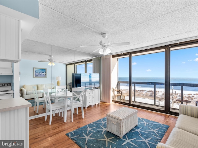 living room with hardwood / wood-style flooring, ceiling fan, and floor to ceiling windows