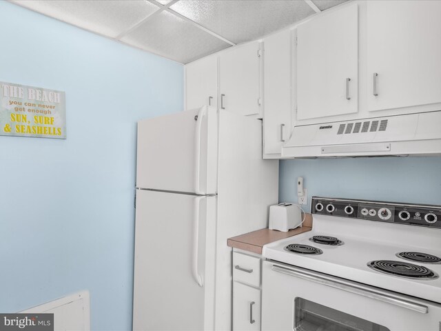 kitchen featuring white cabinetry, a drop ceiling, exhaust hood, and white appliances