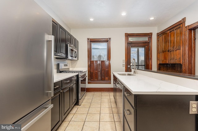 kitchen featuring a kitchen island, sink, light tile patterned floors, and stainless steel appliances