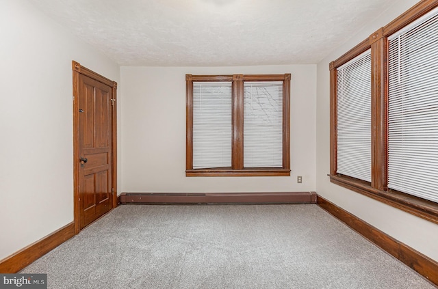 unfurnished room featuring carpet floors, a baseboard radiator, and a textured ceiling