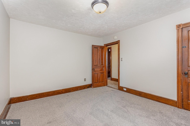 empty room featuring carpet and a textured ceiling