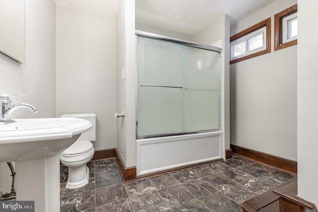 bathroom with enclosed tub / shower combo and toilet