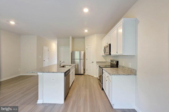 kitchen with white cabinetry, sink, a kitchen island with sink, and appliances with stainless steel finishes