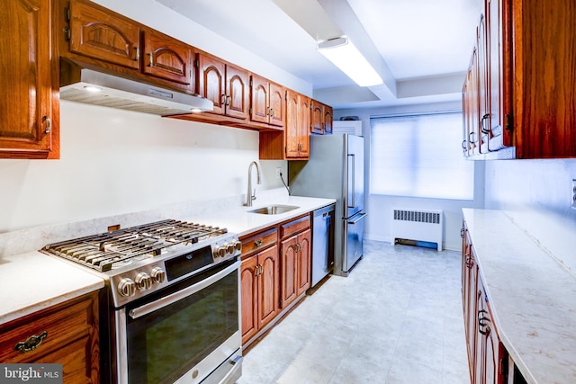 kitchen with appliances with stainless steel finishes, sink, and radiator heating unit