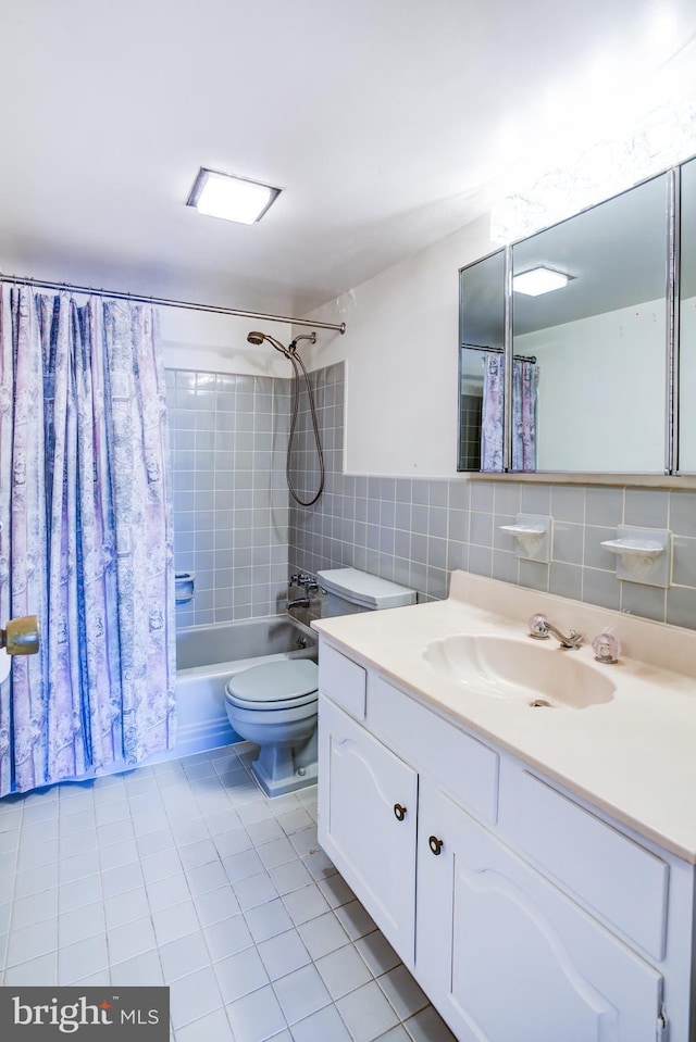 full bathroom featuring shower / tub combo with curtain, tile patterned floors, toilet, tile walls, and vanity