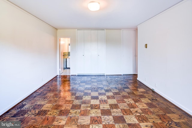 unfurnished bedroom featuring dark parquet floors and a closet