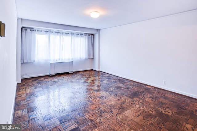 empty room with radiator heating unit and parquet floors