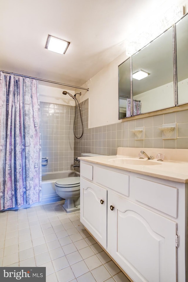 full bathroom with tile walls, vanity, shower / bath combination with curtain, tile patterned floors, and toilet