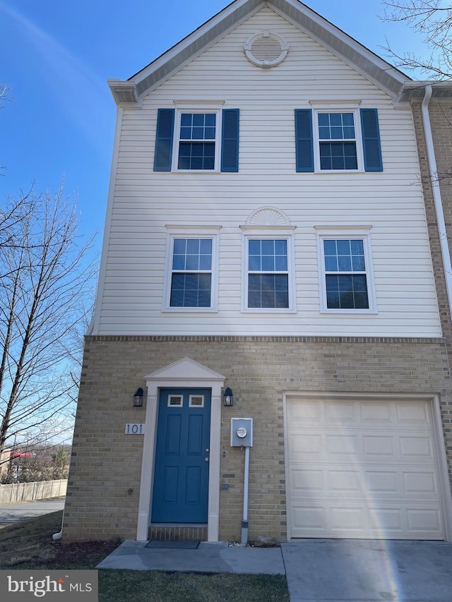 view of front facade with driveway and brick siding